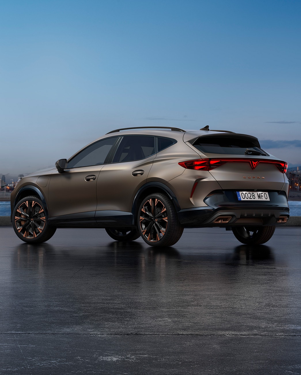 Uusi Century bronze matt -värinen CUPRA Formentor pysäköitynä kävelykadulle veden ääreen iltahämärässä. Taustalla on kaupunkisiluetti sekä pilvenpiirtäjiä ja palmuja laskevan ilta-auringon valossa.